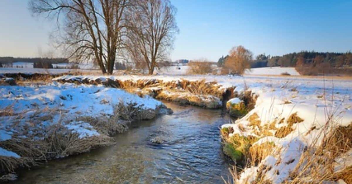 a river running through a snowy field in Stafford
