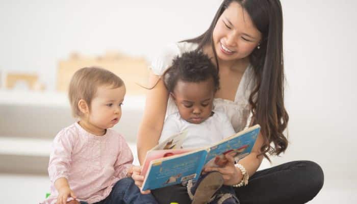 a person reading a book to children
